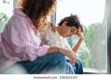 Upset boy sitting on sofa while his mother looking at him
 - Powered by Shutterstock