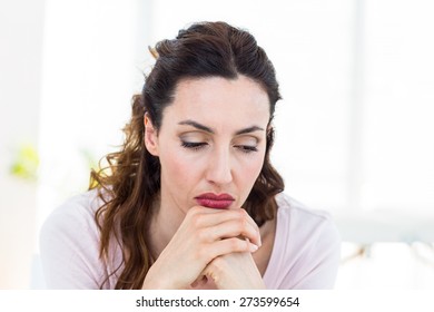 Upset brunette sitting on the couch on white background, Social distancing and self isolation in quarantine lockdown for Coronavirus Covid19 - Powered by Shutterstock