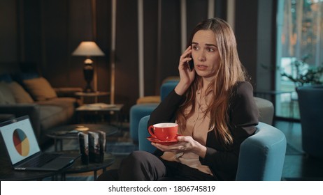 Upset Business Woman Calling Phone At Hotel Lounge. Serious Woman Using Mobile Phone For Call. Dissatisfied Businesswoman Talking Cellphone In Lobby Hotel