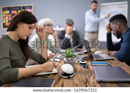 Upset Businesspeople Sitting In Office While Their Colleague Giving Presentation Сток-фото © 