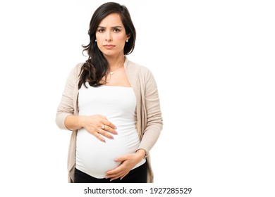 Upset Caucasian Woman Feeling Angry And Concerned. Worried Woman In Her 30s Feeling Angry While Embracing Her Pregnant Belly