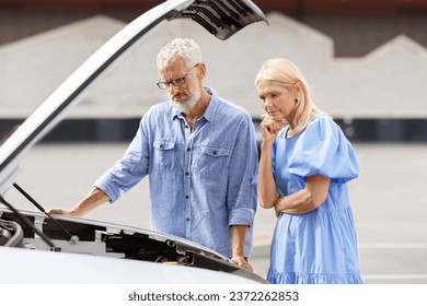 Upset concerned senior couple man and woman wearing casual outfit have road trip, elderly spouses experience problems because of breakdown engine, old man checking auto motor - Powered by Shutterstock