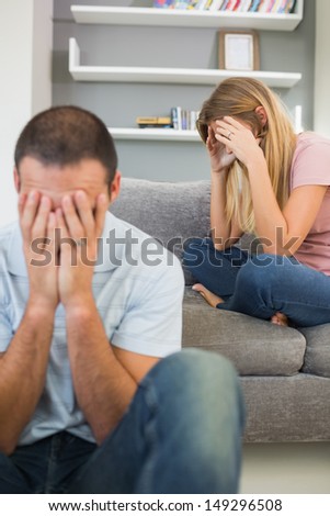 Upset couple having difficulties in sitting room at home