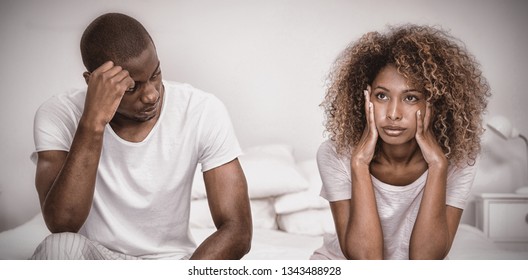 Upset couple ignoring each other after fight on bed in bedroom