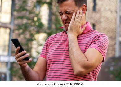 Upset Cringe Man Looking At His Mobile Phone Outdoors