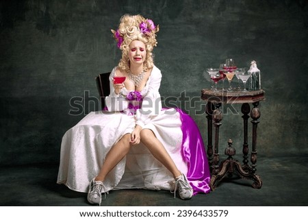 Upset, crying in despair queen, medieval person in old-fashioned dress and modern shoes sitting holding cocktail against vintage background. Concept of afterparty mood, night club, alcohol, retro.