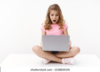 Upset Cute Blond Little Kid Getting Sad And Disappointed Checking School Account, Receive Terrible Mark, Sit Crossed Legs Laptop, Open Mouth Gasping Look Computer Screen Shocked, White Background