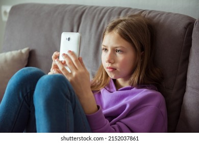 Upset depressed caucasian little kid girl holds mobile phone expresses sorrow and regret blames - Powered by Shutterstock