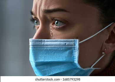 Entsetzlich depressive melancholische traurige weinende Frau in Schutzmaske mit Tränenaugen bei schweren Erkrankungen, Ausbruch von Coronavirus und Grippe-Covid-19-Epidemie. Gesundheitsprobleme