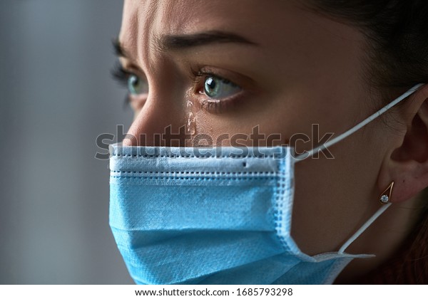Upset\
depressed melancholy sad crying woman in protective face mask with\
tears eyes during serious illness, coronavirus outbreak and flu\
covid-19 epidemic. Health problems\
difficulties
