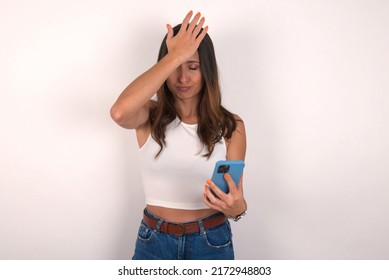 Upset Depressed MODEL Makes Face Palm As Forgot About Something Important Holds Mobile Phone Expresses Sorrow And Regret Blames