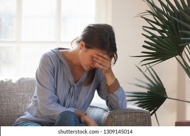 Upset Depressed Young Woman Feeling Tired Bad Down Headache Migraine Sitting On Couch, Sad Desperate Ashamed Female In Trouble Having Problem, Regret Mistake Abortion, Crying Alone At Home