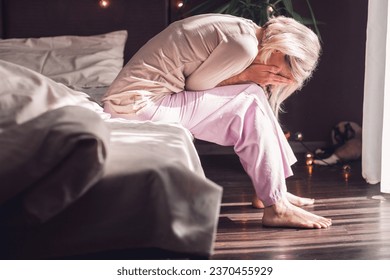 Upset distressed middle aged woman sit on floor in bedroom cry having emotional personal problems breakup or divorce, depressed sad female feel down stressed suffer from infertility or depression  - Powered by Shutterstock