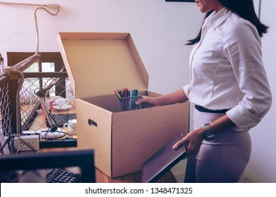 Upset Female Employee Packing Belongings In Box, Frustrated Stressed Girl Getting Fired From Job Ready To Leave On Last Day At Work. Sad Office Worker Desperate From Work
