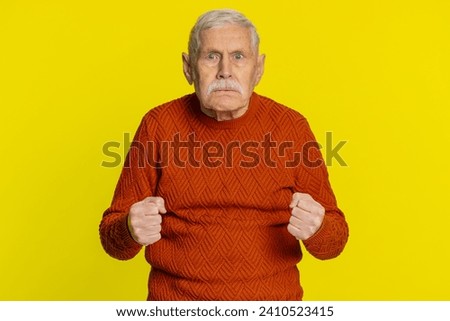 Upset frustrated annoyed senior old man expressing disbelief irritation, feeling bored, disappointed in result, bad news, quarreling, stress. Angry elderly grandfather pensioner on yellow background