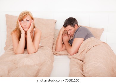 Upset Frustrated And Bored Couple Lying In Bed Having No Sex