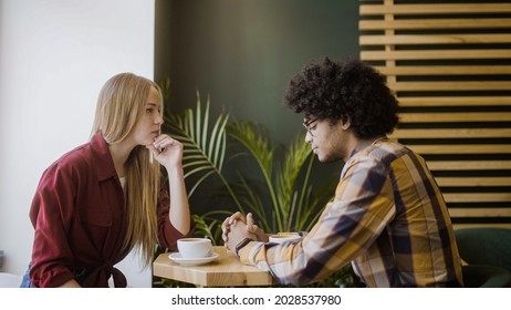 Upset girlfriend sitting in silence with boyfriend in cafe, relationship crisis, breakup