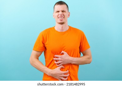 An Upset Guy Squints His Face Holding His Stomach And Feeling Pain. Unwell. Belly. Diarrhea. Male. Holding. Man. Young. Food. Abdominal. Cramp. Disorder. Gas. Guy. Human. Ill. Teeth. Grimaced Face