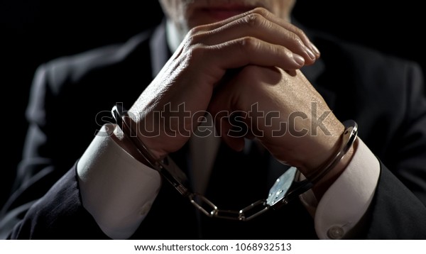 Upset handcuffed man imprisoned for financial
crime, punished for serious
fraud