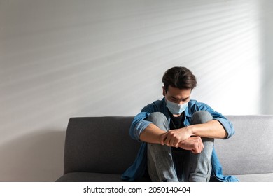 An Upset Health Problem Asian Patient Man Wearing A Face Mask At Home Or Hospital Alone Sad And Waiting For A Doctor. Hospital And Health Care During Coronavirus Or Covid-19 Quarantine Concept.