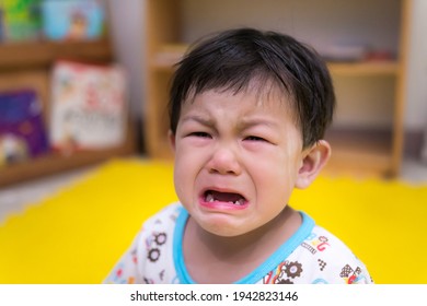 Upset Little Child Is Crying. On A Cloudy Day. Asian Baby Are Sad. Unhappy Boy Aged 1-2 Years Old.