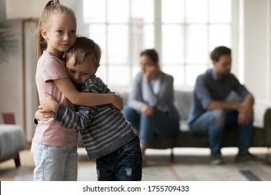 Upset little girl and boy, sister and brother hugging, suffering from parents quarrel close up, family conflict, offended mother and father ignoring each other after argument, children and divorce - Powered by Shutterstock