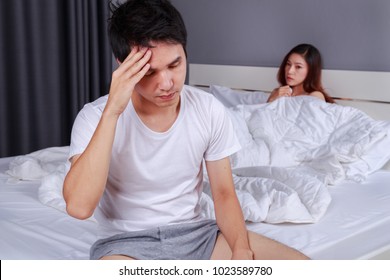 Upset Man Having Problem Sitting On The Bed With His Wife In The Bedroom