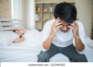 Upset man having problem sitting on the bed after arguing with his girlfriend