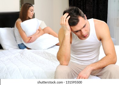 Upset Man Having Problem Sitting On The Bed With His Girlfriend