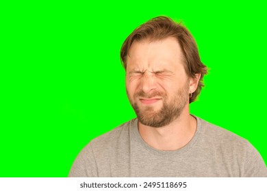 Upset man over plain green background. Adult bearded fun confused shy shamed bemused guy. Green screen chromakey. Handsome sad male looking dissatisfied sadness isolated greenscreen. Expressing sorrow - Powered by Shutterstock