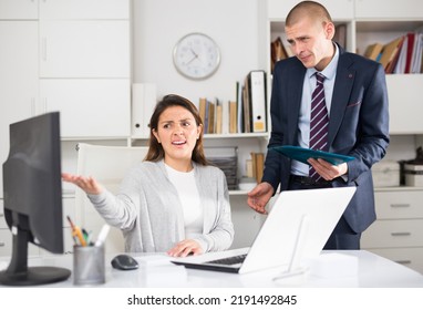 Upset Man Standing Next To Disgruntled Female Boss In Office