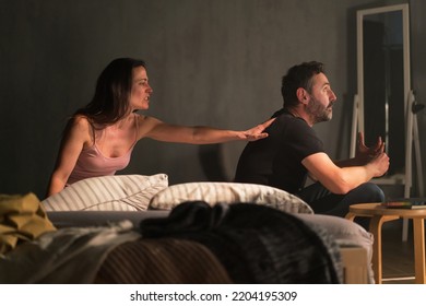 Upset Mid Adult Woman With Her Husband In Bed Arguing, Relationship Problems Concept.