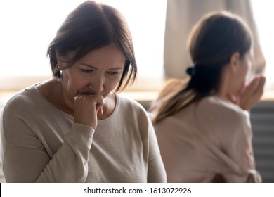 Upset middle-aged mother feel stressed hurt after family fight with adult daughter, sad offended senior mom and grownup child sit separately avoid talking ignore each other have relationship problems - Powered by Shutterstock