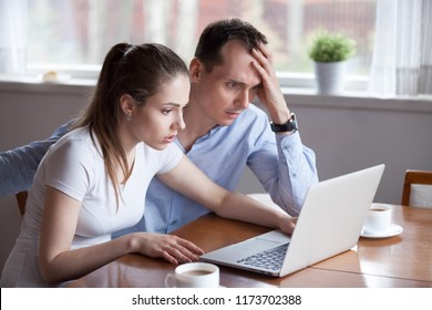 Upset millennial couple disappointed losing money in online lottery, worried man and woman look at laptop screen reading bad news, husband and wife get negative email from bank or eviction notice