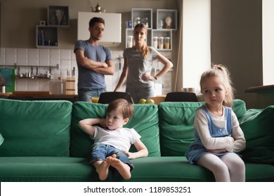Upset offended sister, daughter sitting separately on couch with arms crossed with toddler brother on couch, sofa after fight about tv channel, cartoon choice, little girl and boy ignoring each other - Powered by Shutterstock