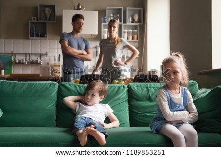 Upset offended sister, daughter sitting separately on couch with arms crossed with toddler brother on couch, sofa after fight about tv channel, cartoon choice, little girl and boy ignoring each other