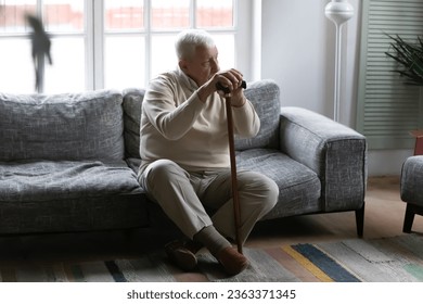 Upset old 80s disabled man sit on couch in retirement house lost in thoughts feeling lonely abandoned, lack communication, sad senior grandfather thinking or mourning at home, elderly solitude concept - Powered by Shutterstock