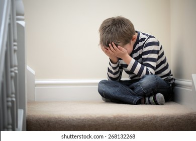 Upset Problem Child With Head In Hands Sitting On Staircase Concept For Bullying, Depression Stress Or Frustration