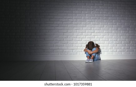 Upset Sad Sad Child Girl In Stress Sits And Cries At An Empty Dark Wall