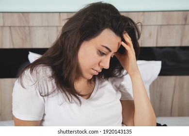 Upset sad woman suffering from in bed. Woman looking sad.