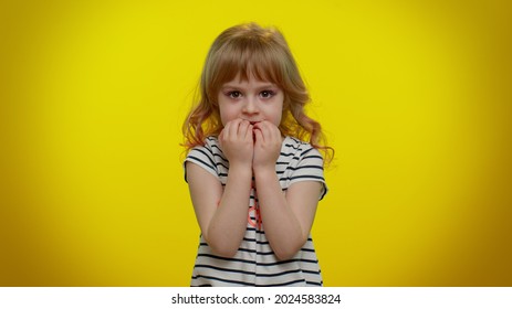 Upset Scared Frightened Child Girl Biting Nails, Feeling Worried Nervous About Serious Troubles, Stress And Anxiety Disorder, Panic Attack, Guilty. Teen Kid Children On Yellow Studio Wall Background