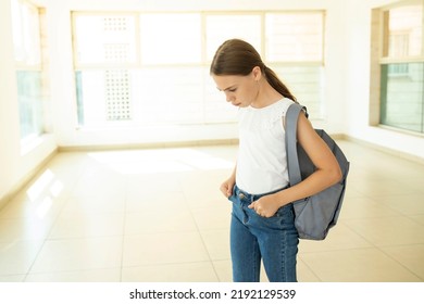 Upset Schoolgirl With A Backpack Standing At School. Girl 10 Years Old, Caucasian, Kid In Stress. Child Is Sad, Walks Along The School Hall. Bullying, Education, Loneliness Concept. Copy Space.