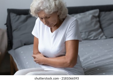 Upset Senior 60s Woman Feeling Strong Stomach Pain After Waking Up, Suffering From Indigestion, Gastric Ulcer, Pancreatitis, Cancer. Older Woman Having Abdomen Health Problems, Holding Belly