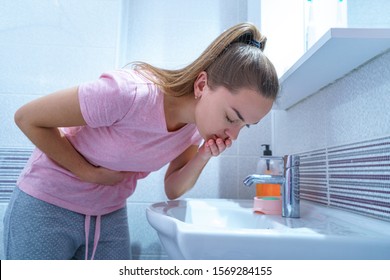 Upset Sick Woman Suffers From Nausea And Vomiting Due To Digestive And Belly Illness Problems At Home. Morning Toxicosis At First Trimester Of Pregnancy. Stomach Infection Due To Food Poisoning