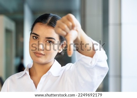 upset south asian, Indian woman office worker pointing rejecting thumb down hand gesture Foto stock © 