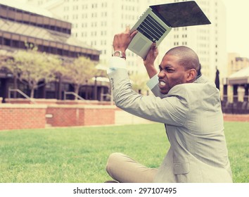 Upset Stressed, Angry Business Man Throwing His Tablet Computer, Laptop Sitting Outside Corporate Office. Negative Human Emotions, Facial Expressions, Feelings, Reaction, Life Perception