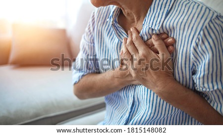 Upset stressed mature middle aged woman feeling pain ache touching chest having heart attack, sad worried senior older lady suffers from heartache at home, infarction or female heart disease concept