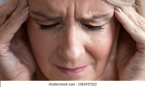 Upset Stressed Middle Aged Old Woman Feel Pain In Sore Head Terrible Migraine, Sad Tired Senior Middle Aged Lady Suffer From Mental Problem, Panic Attack Having Strong Headache Concept, Close Up View