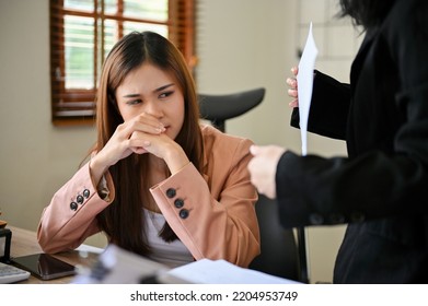 Upset And Stressed Millennial Asian Businesswoman Or Female Office Worker Gets A Work Complaint From Her Female Boss.