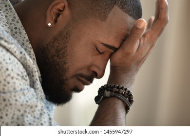 Upset stressed young african american man coping with strong headache concept, upset exhausted black guy feeling frustrated depressed tired touching forehead suffer from migraine, close up side view - Shutterstock ID 1455947297